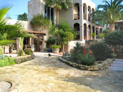 Rear side of the house with exotic plants and covered sitting areas